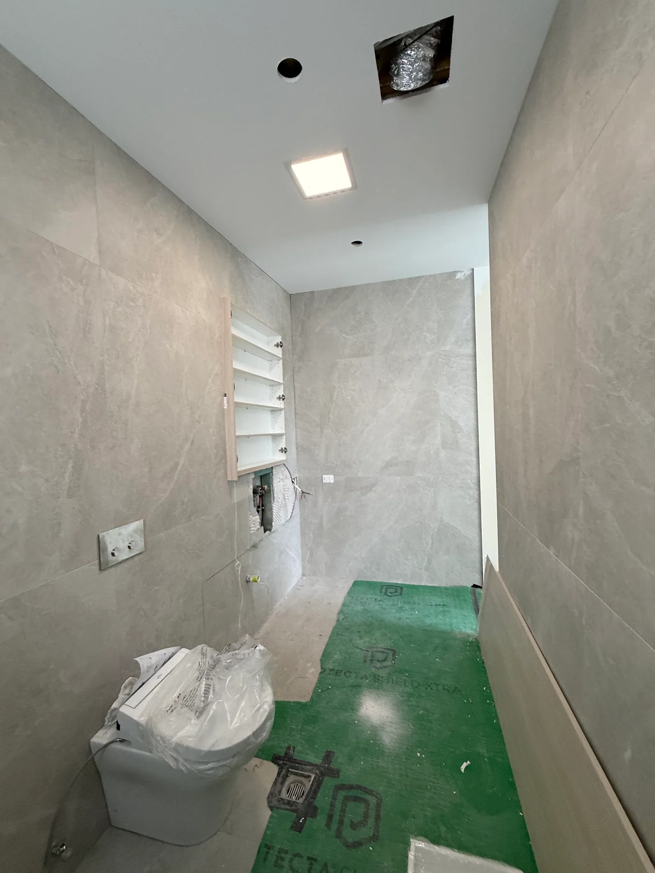 Illuminated ceiling panel in a Kensington bathroom during fit-out
