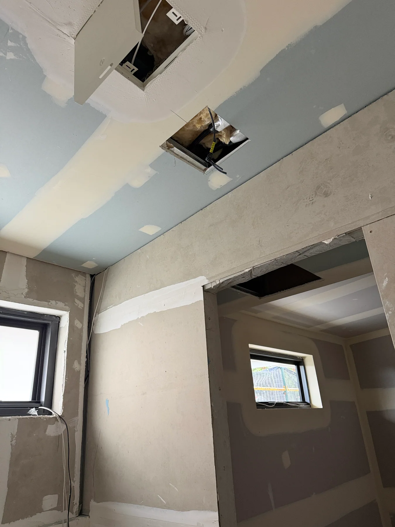 Prepared ceiling openings and wiring visible during a Kensington new-build fit-out