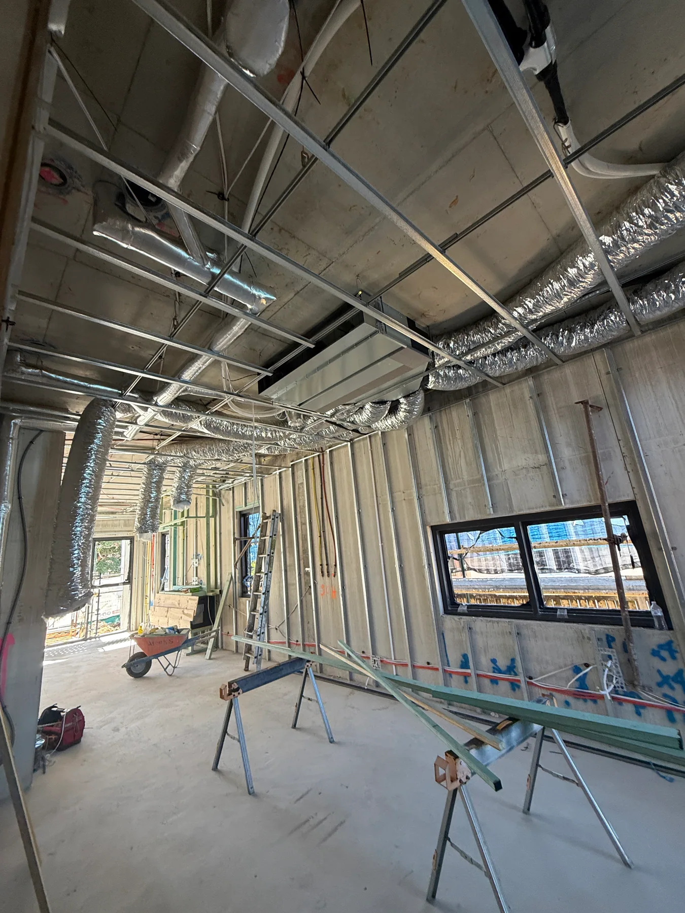 Kensington new-build interior with ceiling framing and mechanical services exposed during construction