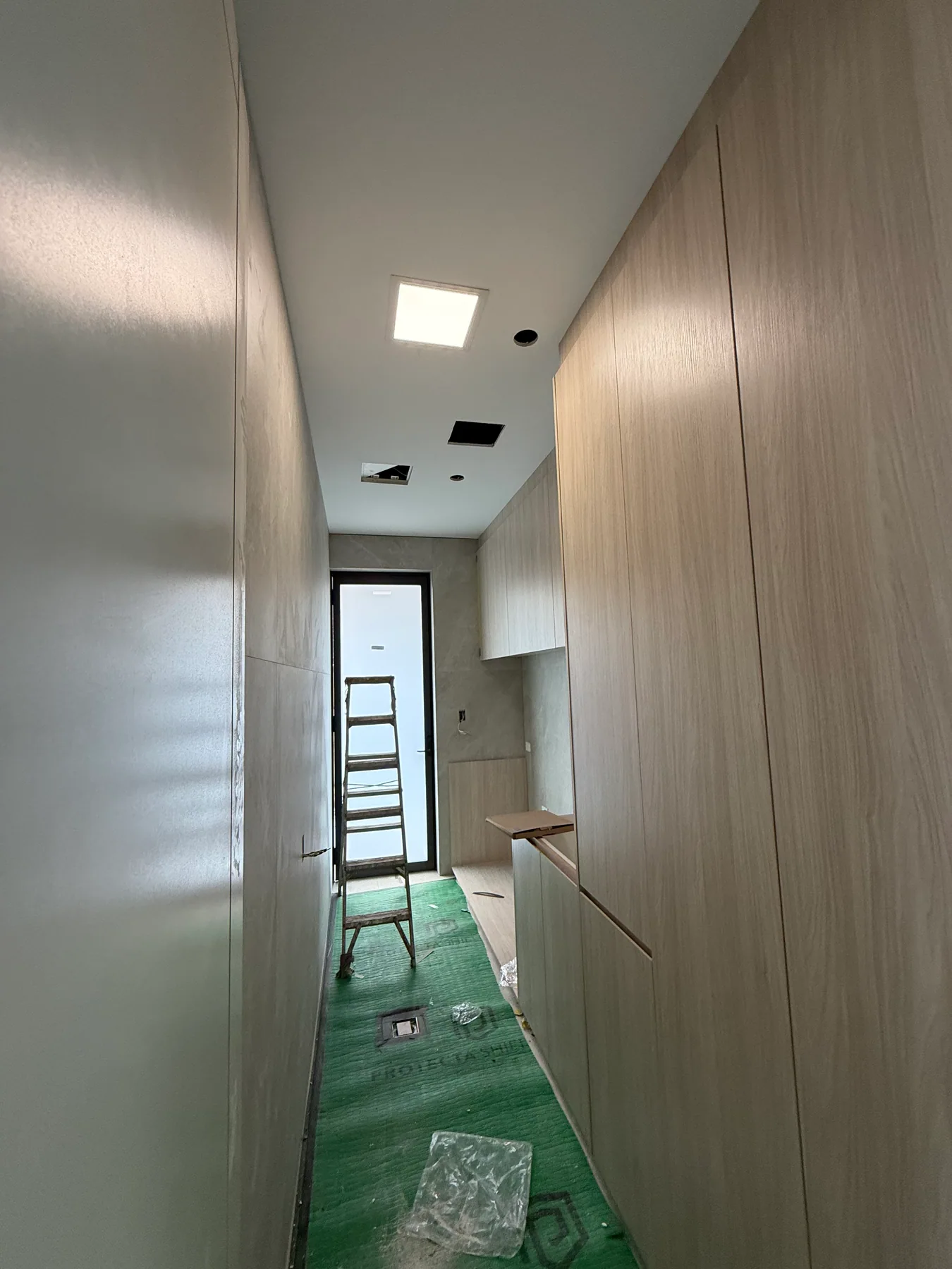 Illuminated solar LED ceiling panel in a Kensington hallway with other ceiling openings still visible