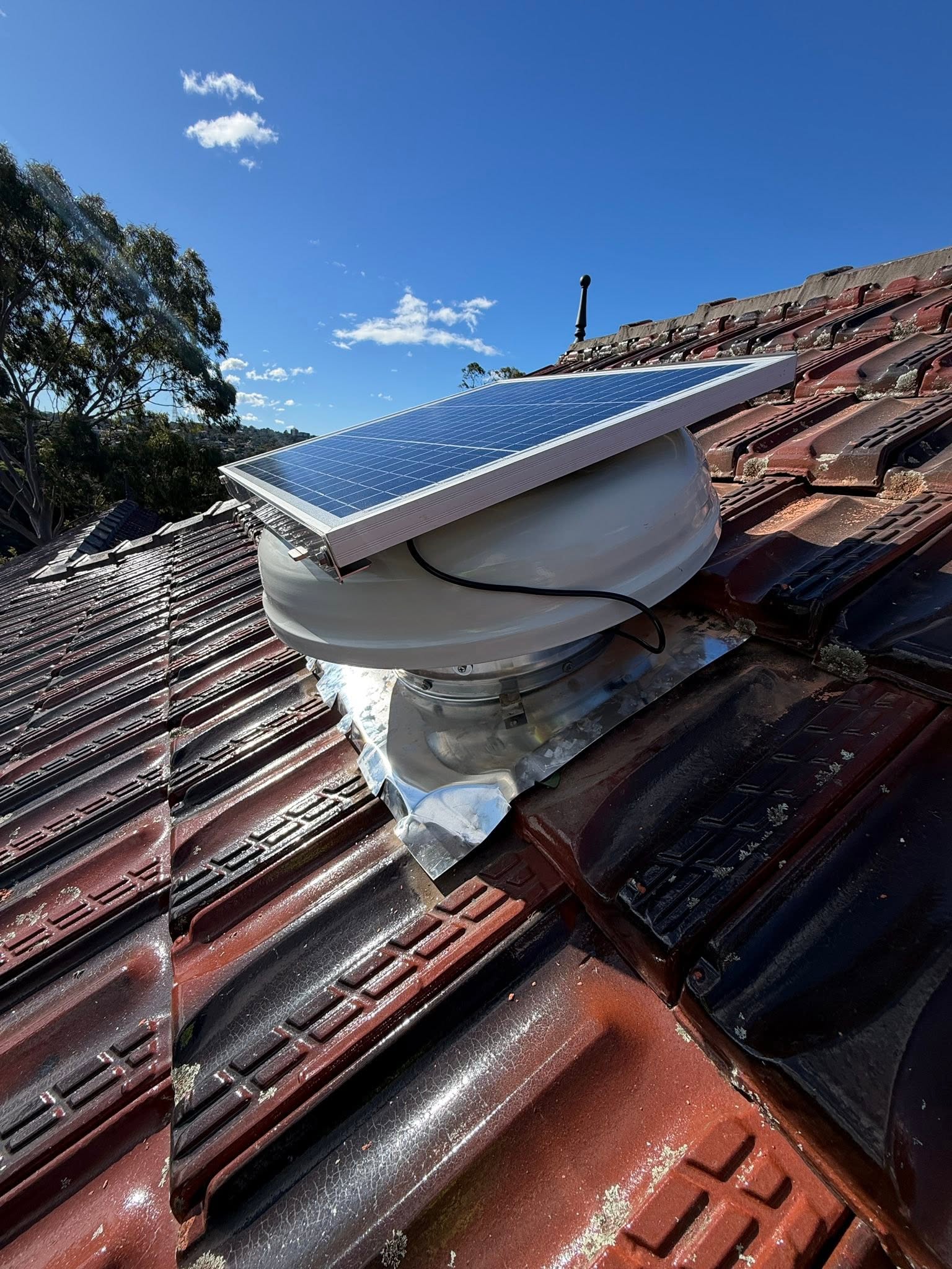 SolarWhiz extraction fan and solar panel installed on a tiled roof in Longueville