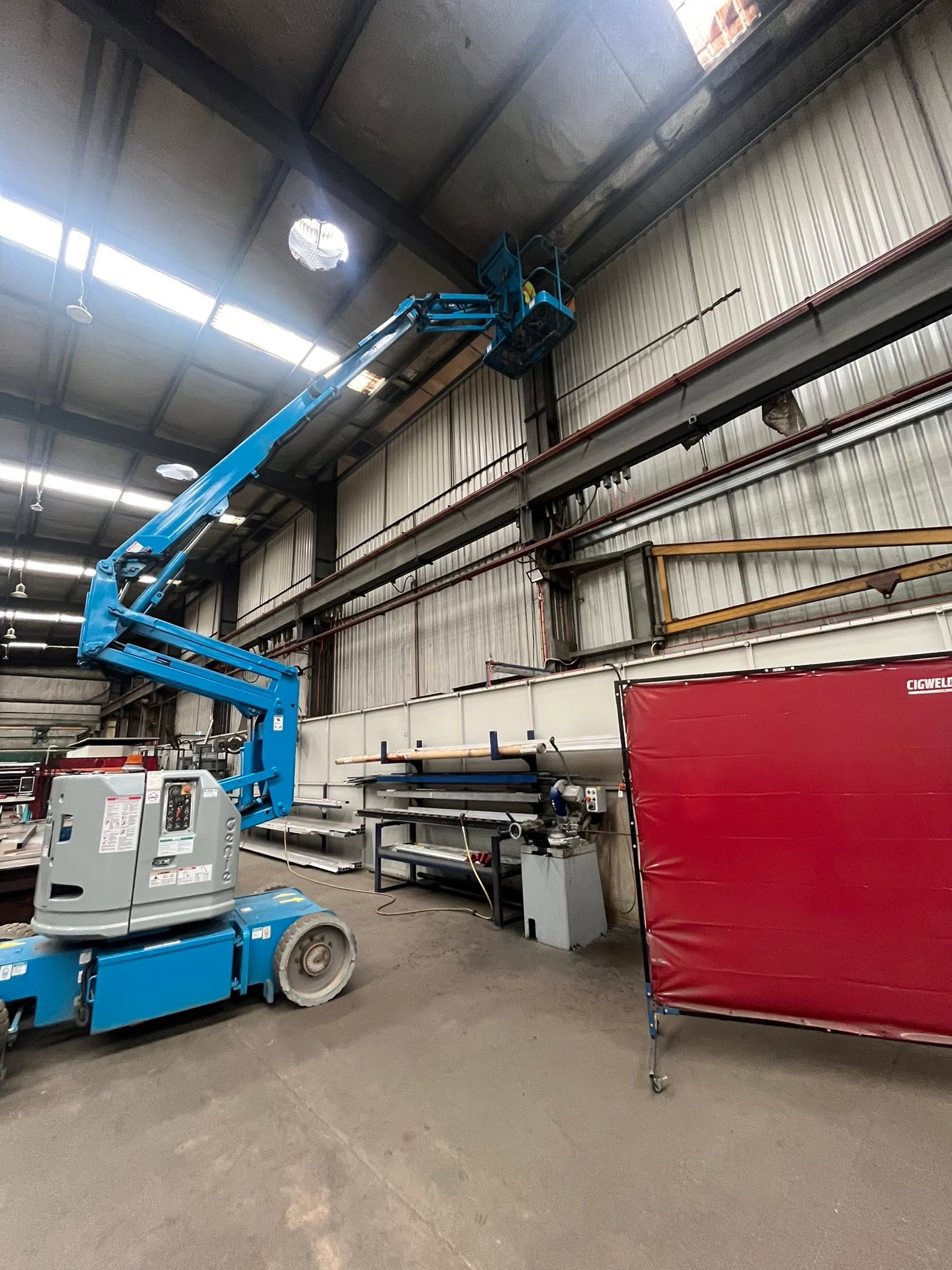 Mobile elevated work platform reaching toward a high warehouse ceiling