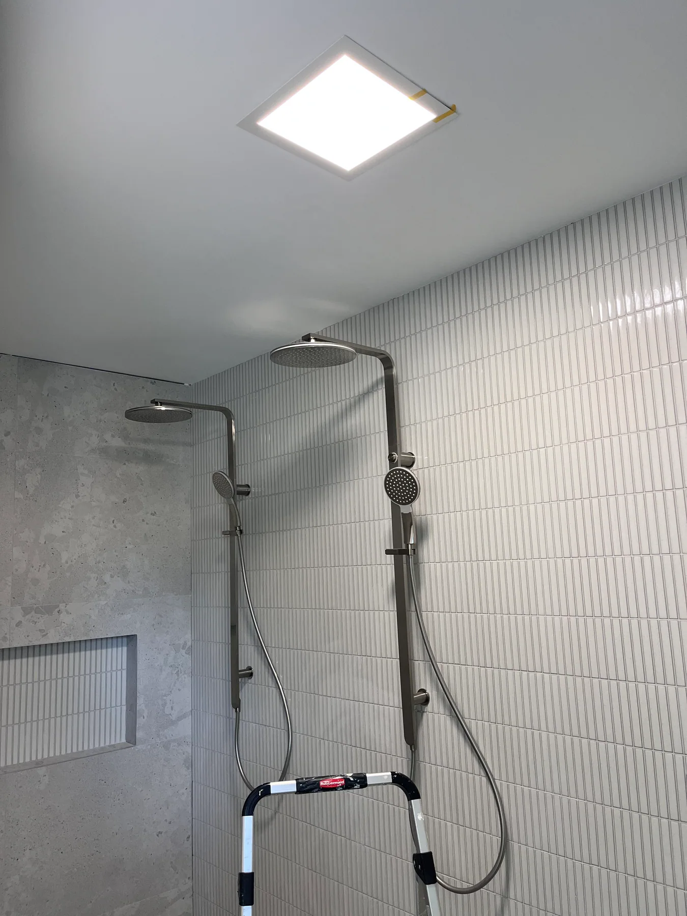 Illuminated rectangular ceiling panel above a bathroom shower in Randwick